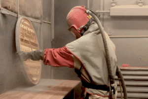 Showing someone sandblasting a sign